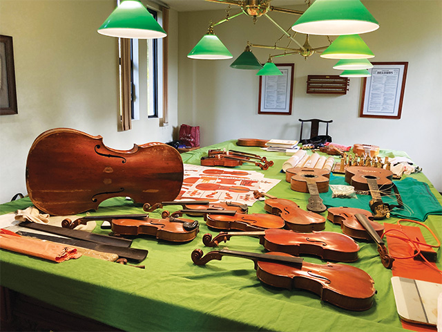 Violin iii Collection of various instruments some finished, some for repair, with violin specification posters