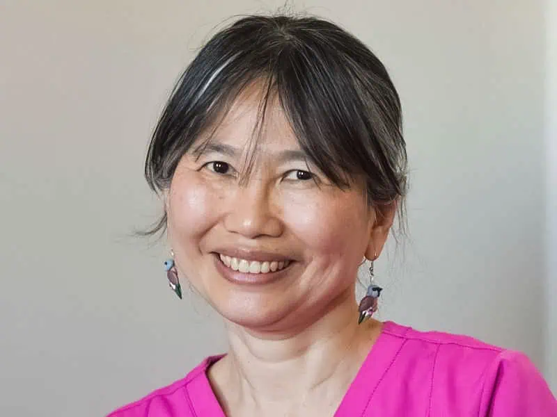 A woman smiling in a pink top, promoting Dooral Roundup Magazine in Australia.