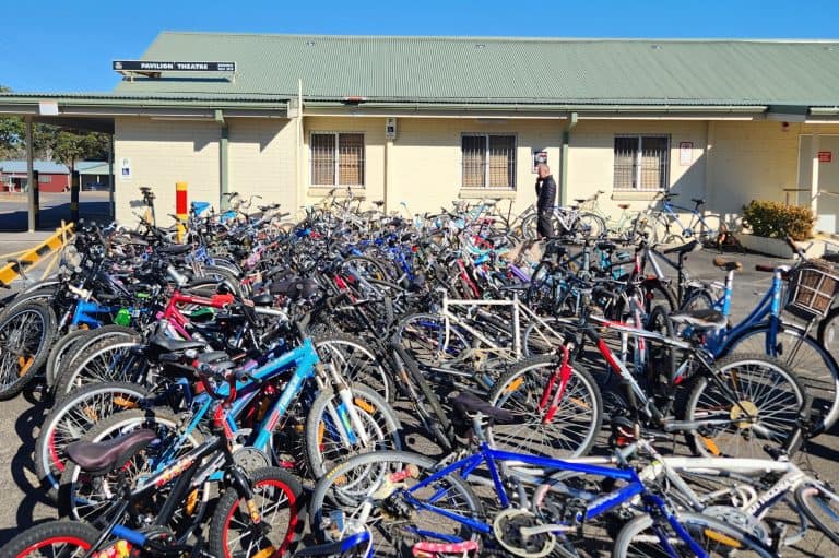 Bicycle parking area at Dooral Roundup Magazine office in Australia, with numerous bikes and a perso.